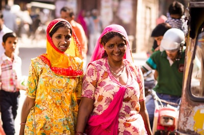 两个女人穿着传统服饰走在街头而微笑的白天
